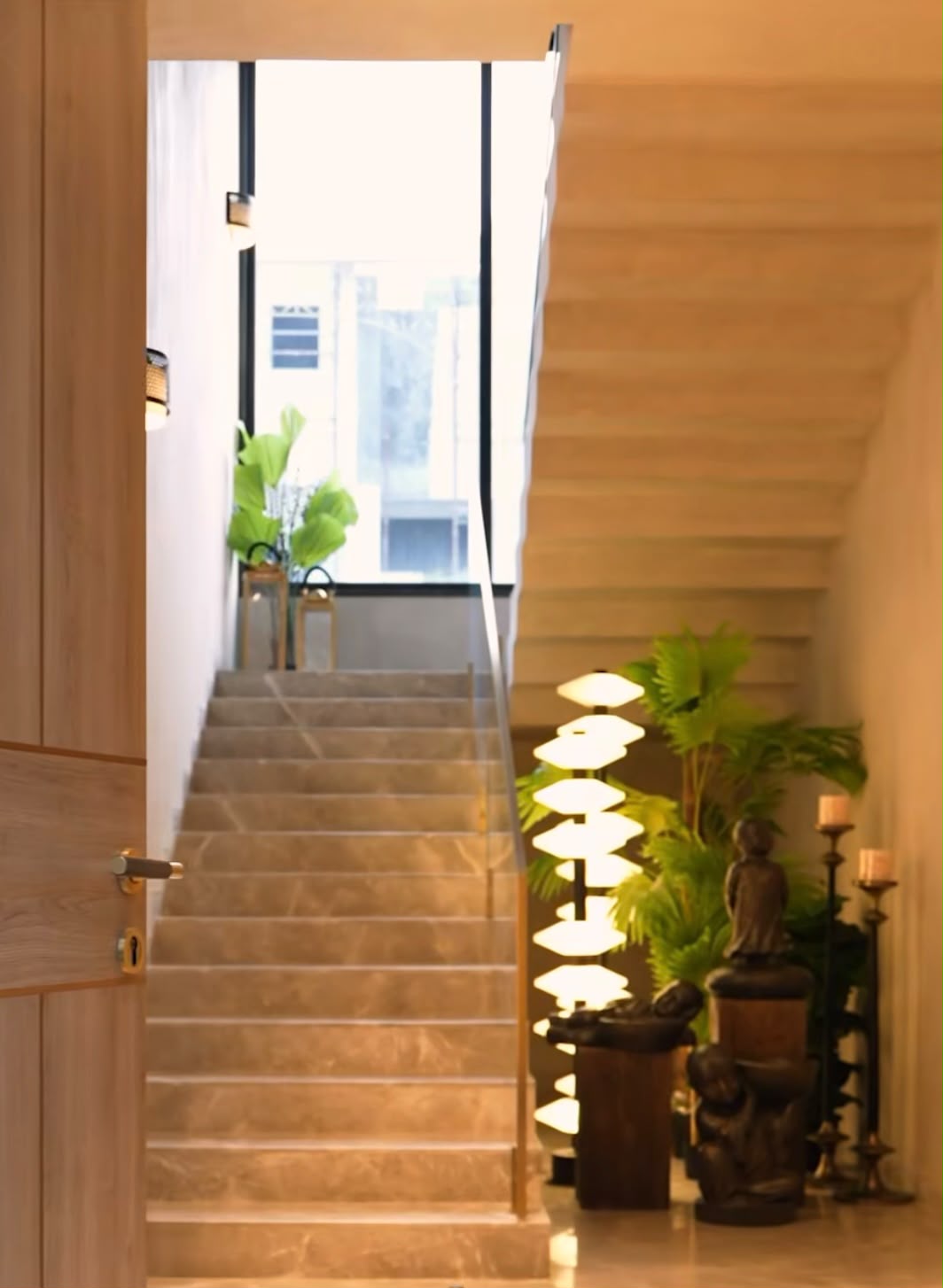 Marble stair with brass rail, planting and sculptural floor lamp